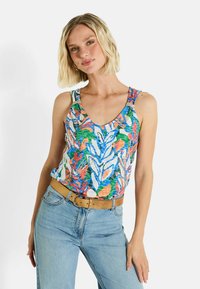 Top sin mangas con estampado floral en vibrantes tonos azules, verdes y naranjas, con tirantes finos y un escote en forma de lágrima, combinado con jeans azul claro y un cinturón beige.