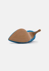 Ljusblå högklackad sko med spetsig tå, mjukt mockamaterial och en tan-färgad texturerad sula, utrustad med ett smalt ankelsnöre.