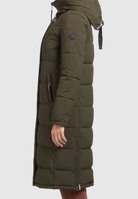 Oliven grøn lang pufferjakke med hætte, der har horisontalt quiltet design, sidelommer og et logo-patch på venstre ærme.