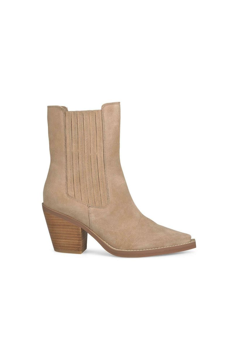 Bottine en suède beige à bout pointu, présentant des coutures verticales sur les côtés et un talon en bois empilé et effilé.
