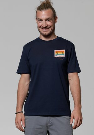 Navyblauwe katoenen T-shirt met een gekleurde cassetteafbeelding op de linker borst; korte mouwen en een ronde hals.