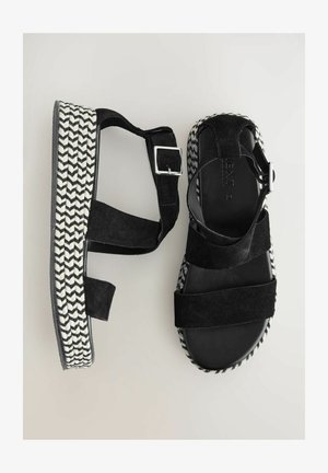 Zwarte suède platform sandalen met een geweven houndstooth patroon op de zool, voorzien van verstelbare enkelbandjes en een platte hak.