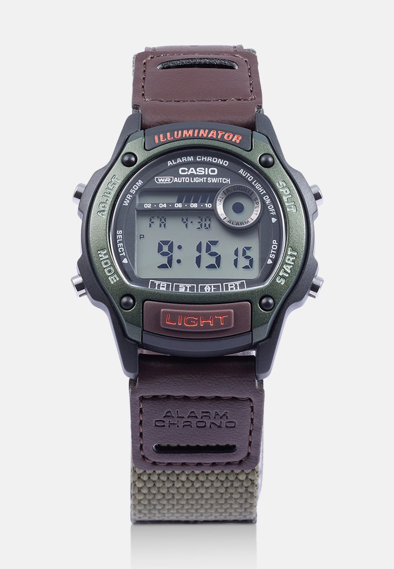 Cyfrowy zegarek Casio z zieloną plastikową obudową, brązowym skórzanym paskiem i tekstylnymi akcentami. Posiada podświetlany wyświetlacz, wiele przycisków oraz wodoodporność.