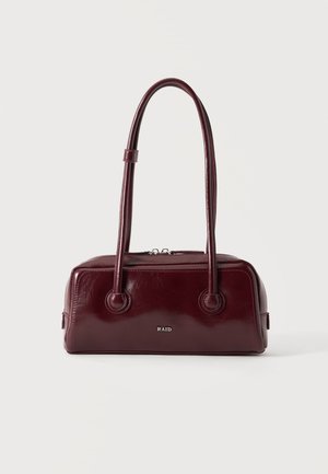Sac à main rectangulaire rouge foncé avec deux longues anses et une fermeture éclair sur le dessus, présenté sur un fond clair uni.
