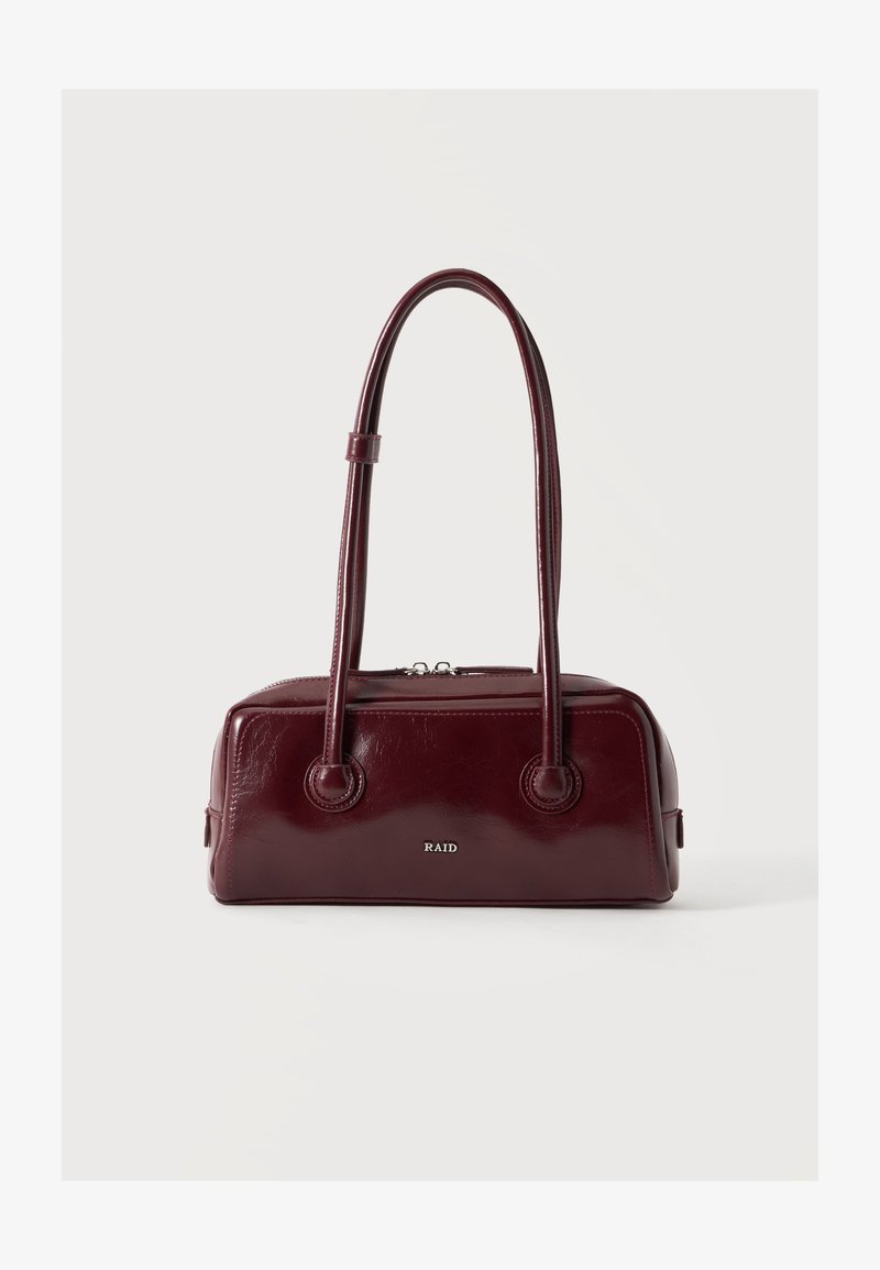 Sac à main rectangulaire rouge foncé avec deux longues anses et une fermeture éclair sur le dessus, présenté sur un fond clair uni.