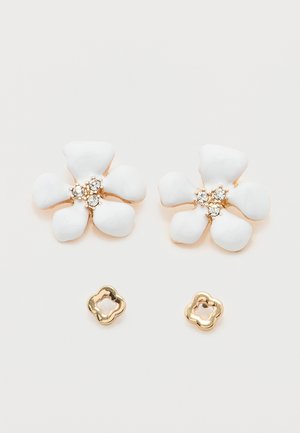 Ζεύγος σκουλαρικιών σε χρυσό τόνο με λευκά σμάλτα σε σχήμα πενταπέταλων λουλουδιών και τρεις μικρές διάφανες στρας στο κέντρο, συνοδευόμενα από καρφίτσες σε χρυσό τόνο με σχήμα λουλουδιού.