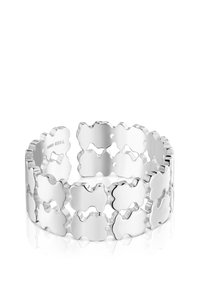 Brazalete de plata con un patrón enlazado de formas con bordes ondulados y recortes. Acabado liso y brillante con textura pulida.