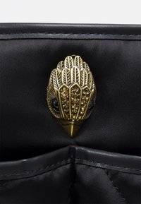 Svart satinväska med inredning som har ett fågelformat lås i guldton med detaljerad fjäderdesign och inlagda rhinestones.