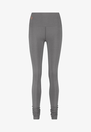 Harmaat legginsit, jotka on valmistettu joustavasta kankaasta, ja joissa on korkea vyötärö sekä röyhelöyksityiskohta nilkoissa. Korostettu hienovaraisella logo-ompelulla.