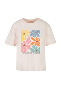 Light pink cotton t-shirt featuring colorful flower graphics in yellow, pink, orange, blue, and green with the text "HAPPINESS BLOOMS HERE."