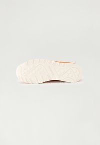 Reebok-sko såle med en teksturert hvit gummioverflate med zigzagmønster og sirkulære innsnitt, designet for grep og holdbarhet.