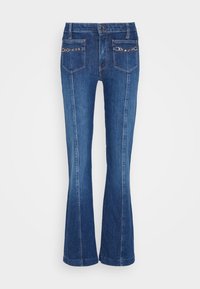 Denim flared jeans in medium blue with a mid-rise waist, featuring two back pockets accented with circular hardware and contrast stitching.