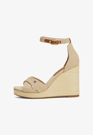 Sandalias de cuña beige con correas de lona, cruzadas en el frente, con correa en el tobillo y hebilla, y tacón de cuña tejido texturizado.