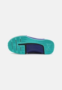 Suola della scarpa con un motivo testurizzato a zigzag in turchese e nero. Presenta un accento viola e un design segmentato per la flessibilità.