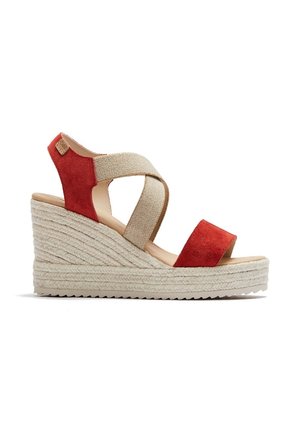 Sandalia de cuña con plataforma alta de yute trenzado, tiras elásticas beige entrecruzadas y tiras de ante rojas en el dedo y el talón.