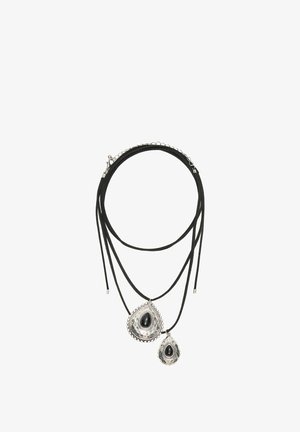 Doppellagige schwarze Kordelkette mit zwei silbernen tropfenförmigen Anhängern, jeder mit einem schwarzen Stein in der Mitte und dekorativen Rändern.