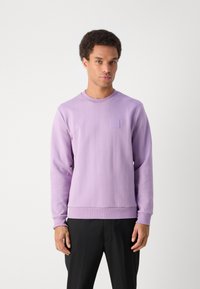 Μωβ φούτερ με μακριά μανίκια και ραμμένο λαιμό crew, με υφασμάτινες κάθετες ρίγες και μικρή τετράγωνη λεπτομέρεια στο στήθος. Μαλακό ύφασμα.