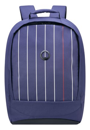 Sac à dos en tissu violet foncé avec des rayures verticales blanches et rouges. Il présente une poignée supérieure, des bretelles rembourrées et un logo circulaire.