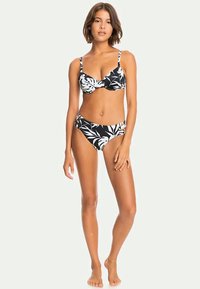 Black bikini set featuring white tropical leaf patterns. The top has thin straps and a supportive design, while the bottom is a mid-rise style.