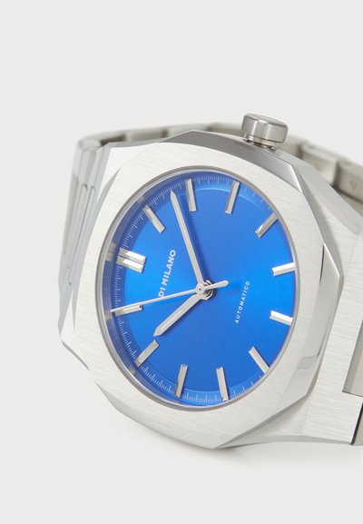 Silver stainless steel watch with an octagonal case, blue dial, silver hour markers, and three hands. Features a textured metal bracelet.