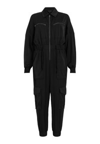Combinaison noire en matériau doux, dotée d'une taille élastique, de deux poches poitrine et de deux poches latérales cargo avec fermetures éclair.