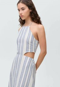 Striped halter top in white and blue, featuring a fitted design with a side cutout and lightweight fabric texture.