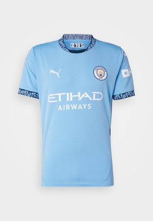 Camisa de fútbol azul clara de mangas cortas, con el logo de Puma, la impresión "ETIHAD AIRWAYS" y detalles estampados en el cuello y las mangas.