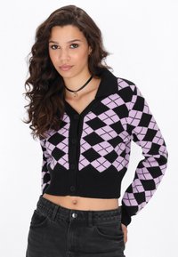 Svart och lavendel argyle cardigan med V-hals, knäppning, ribbat nederkant och långa ärmar, som bärs över högmidjade svarta jeans.
