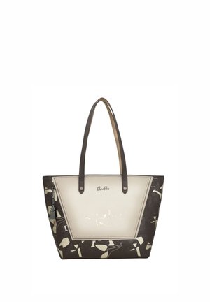 Borsa tote con lati marrone scuro decorati, pannello frontale beige con logo e testo metallico, e due spallacci marrone scuro.