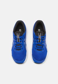 Baskets de sport bleues avec une tige en mesh, des lacets noirs contrastants et des accents blancs. Semelle rembourrée pour plus de confort.
