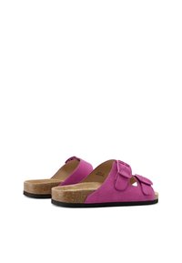 Sandali slide in suede fucsia con due cinturini regolabili, una soletta in sughero naturale e una suola in gomma nera. Design con punta arrotondata.