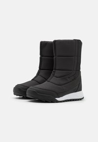 Botas de tobillo aisladas negras que cuentan con un diseño acolchado, tejido texturizado y una suela de goma blanca con un patrón de tracción antideslizante.