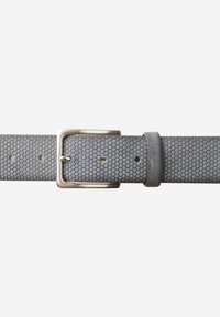 Ceinture grise texturée avec un motif en nid d'abeille, boucle en métal argenté et passant en cuir. Des trous pour les ajustements sont visibles sur la sangle.