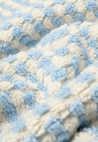 Manta de textura pom-pom en colores azul claro y blanco alternos, con una tela suave y esponjosa para proporcionar calidez y comodidad acogedora.
