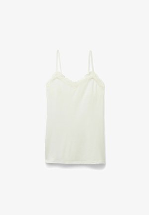 Camisole i off-white bomuld med blondekant langs udskæringen. Har tynde justerbare stropper og en blød, glat tekstur.