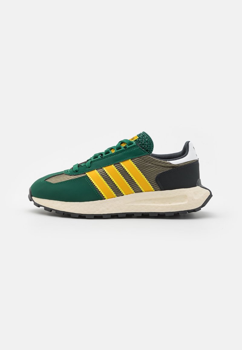 Green and yellow athletic shoes with a textured upper, three yellow stripes, black accents, and a thick white rubber sole.