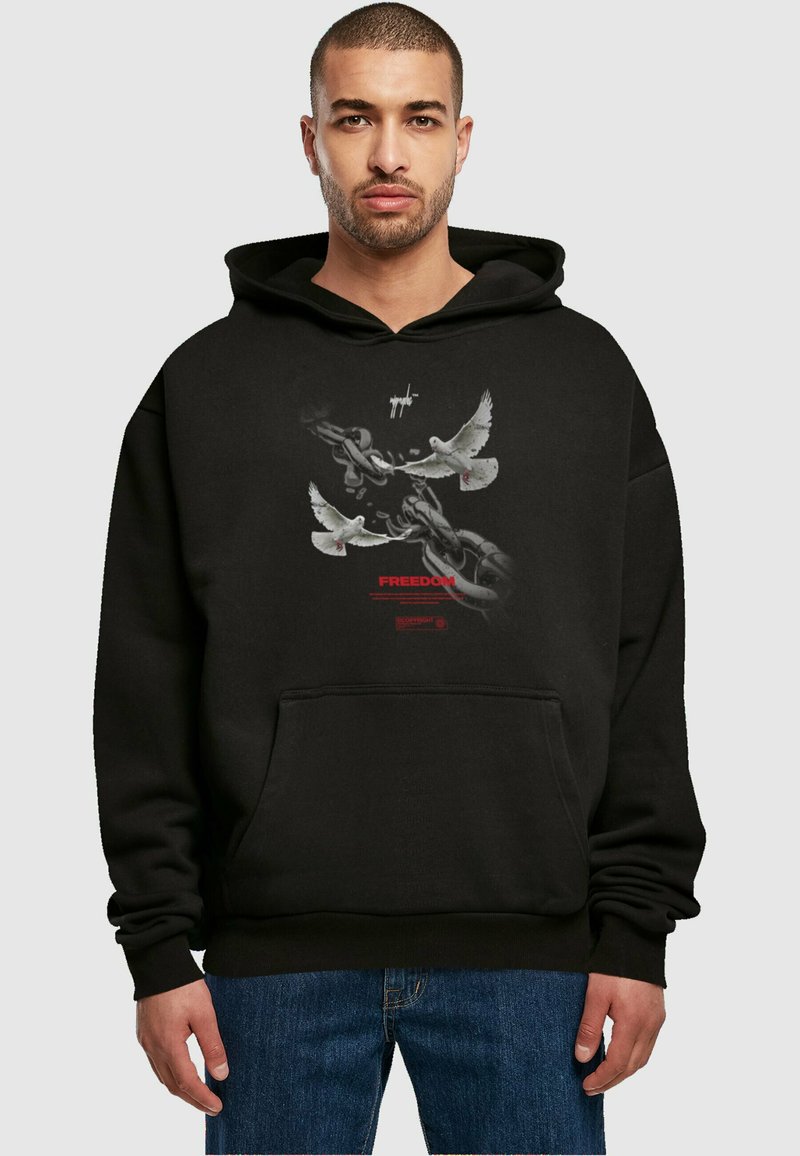 Felpa nera con cappuccio che presenta un grafico di colombe e catene. Il testo reca la scritta "LIBERTÀ" in rosso. Vestibilità classica con tasca frontale.