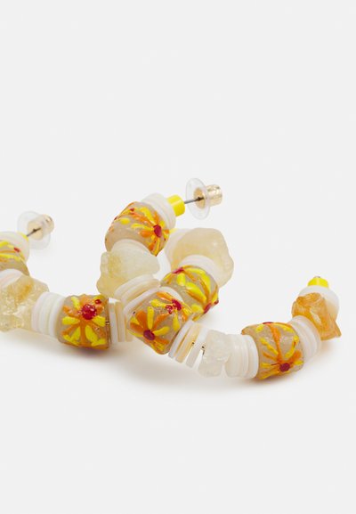 Brincos coloridos de contas com pedras transparentes, acentos brancos e amarelos, e padrões florais em laranja, dispostos em um design curvado.