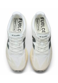 Zapatillas de running blancas con una parte superior de malla transpirable, con acentos en gris oscuro, superficies texturizadas y una entresuela amarillo claro.