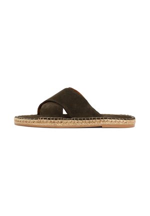 Donkerbruine suède slip-on sandaal met gekruiste banden en gevlochten jute zoolstiksel op een witte achtergrond.