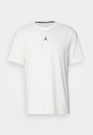 Hvid kortærmet T-shirt lavet af bomuld, med et sort Jumpman-logo på brystet og en rund halsudskæring med et sort indvendigt mærke.