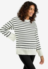 Pullover-Sweater in Creme mit schwarzen horizontalen Streifen. Gerippte Bündchen und Saum. Weiches, strukturiertes Strickmaterial. Lockere Passform und runder Ausschnitt.