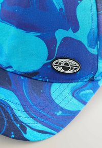 Blaue und türkisfarbenen Kappe mit marmoriertem Muster, ausgestattet mit einem schwarzen ovalen Logo und genähten Details auf dem Schirm.