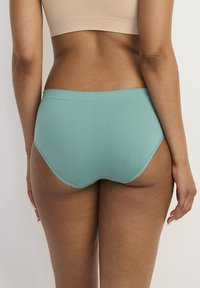Högmidjade teal underkläder med ett mjukt, stretchigt tyg och sömlös design för komfort, med en enkel elastisk midjeband.