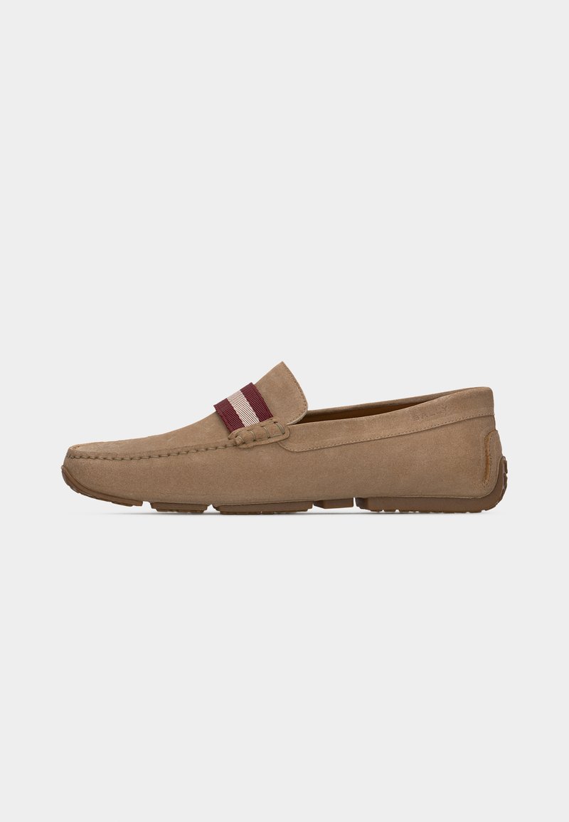 Mocassin en daim beige avec une sangle en tissu rayée rouge et blanche, détails cousus, et semelle en caoutchouc, présenté de profil.