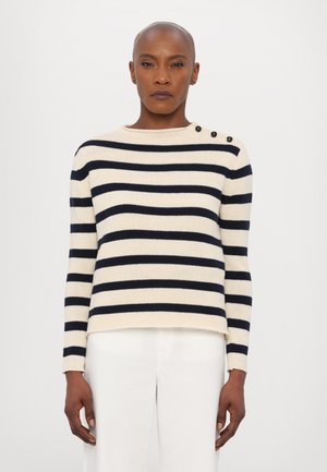 Maglione a righe crema con strisce orizzontali blu navy, dotato di un collo rotondo e tre bottoni neri sulla spalla sinistra; texture a coste.