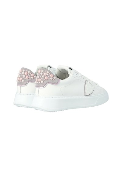 Sneaker bianche a collo basso con suole spesse, con linguette del tallone in suede viola chiaro decorate con perline simili a perle rosa e bianche.