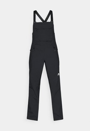 Schwarze Latzhose aus strapazierfähigem Stoff, mit verstellbaren Trägern, einer Fronttasche und seitlichen Reißverschlüssen für ein einfaches An- und Ausziehen. Minimalistisches Design mit Logo.