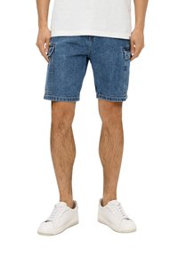 Denim shorts in medium blue, met een rechte snit, zijzakken en een gescheurde zoom. Gecombineerd met witte sneakers en een eenvoudig wit T-shirt.