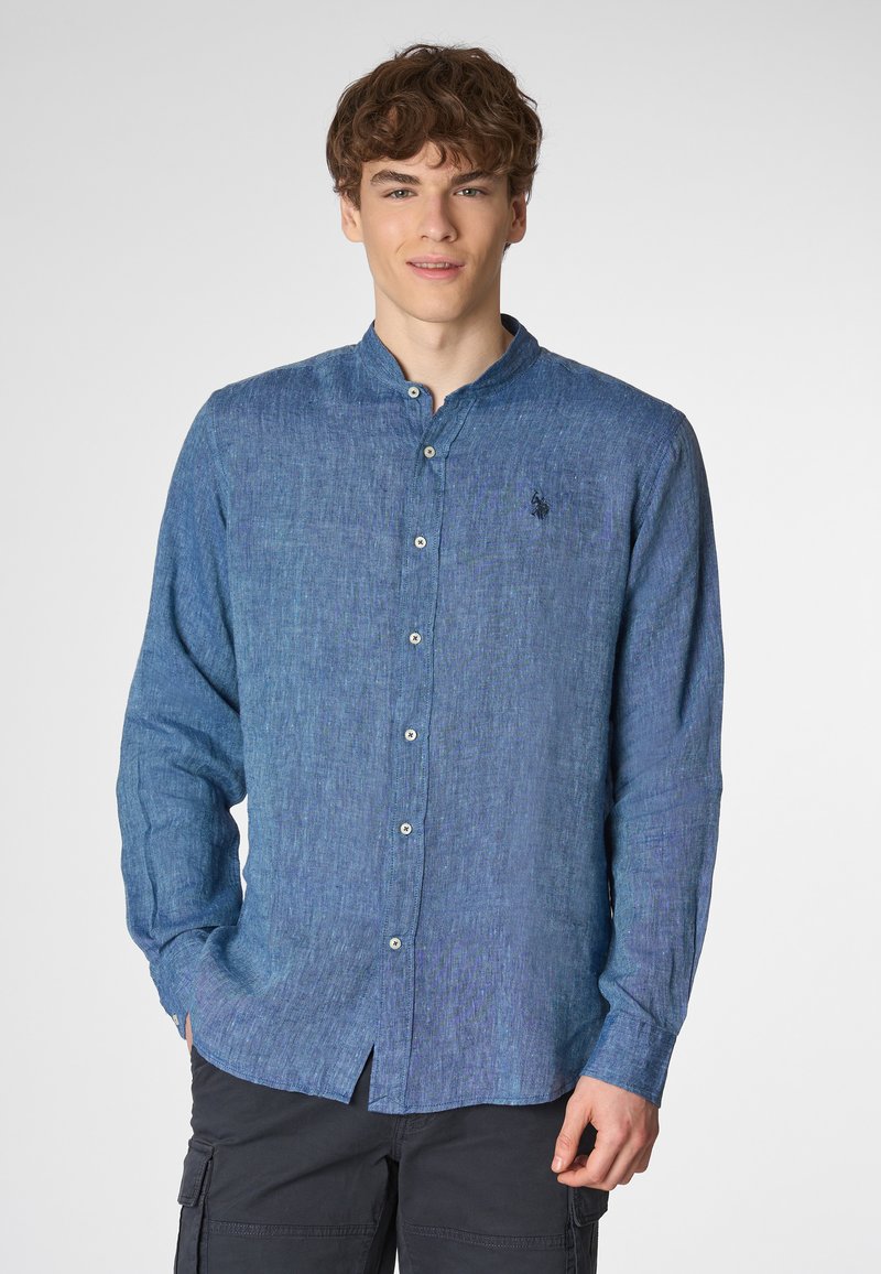 Camicia button-up a maniche lunghe di colore blu scuro, realizzata in tessuto strutturato, con colletto alla francese e un piccolo logo sul petto, con una vestibilità rilassata.